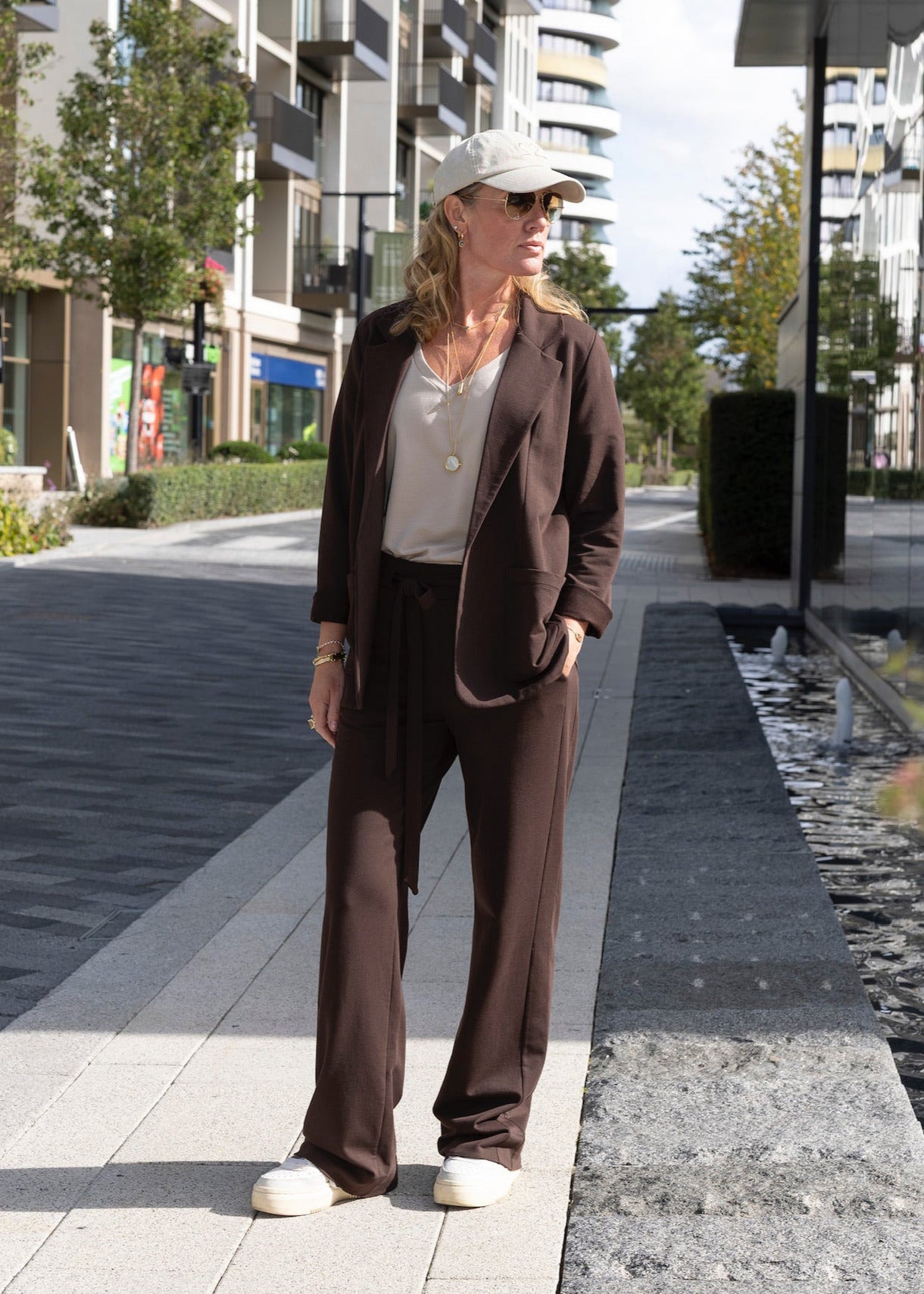 Woman in a brown suit standing on a city street